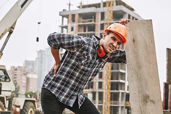 Photo of construction working holding his hurting back