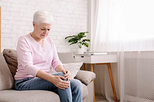 Photo of woman holding her leg in pain